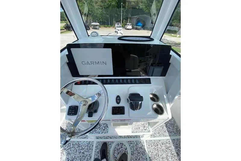 Slide: The Image of 2024 Sea Hunt BX 25 FS boat dashboard with Garmin navigation system and steering wheel. - 12