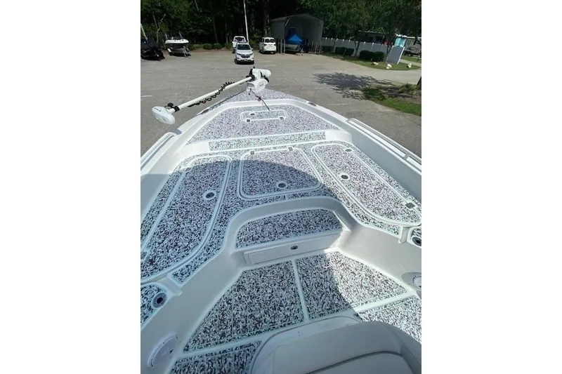 Slide: The Image of 2024 Sea Hunt BX 25 FS boat deck with textured flooring, parked outdoors. - 20