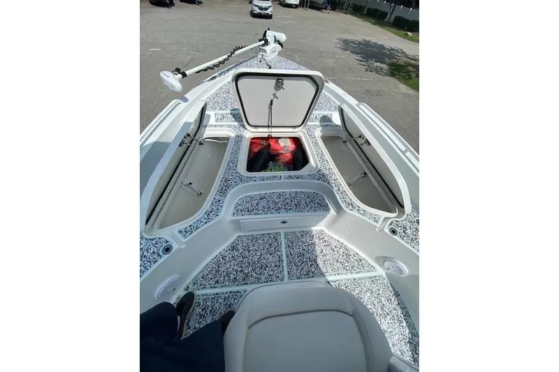 Slide: The Image of 2024 Sea Hunt BX 25 FS boat deck with open storage compartments and trolling motor. - 21