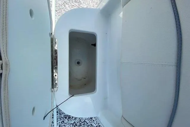 Slide: The Image of 2024 Sea Hunt BX 25 FS boat storage compartment, open lid, white interior. - 26