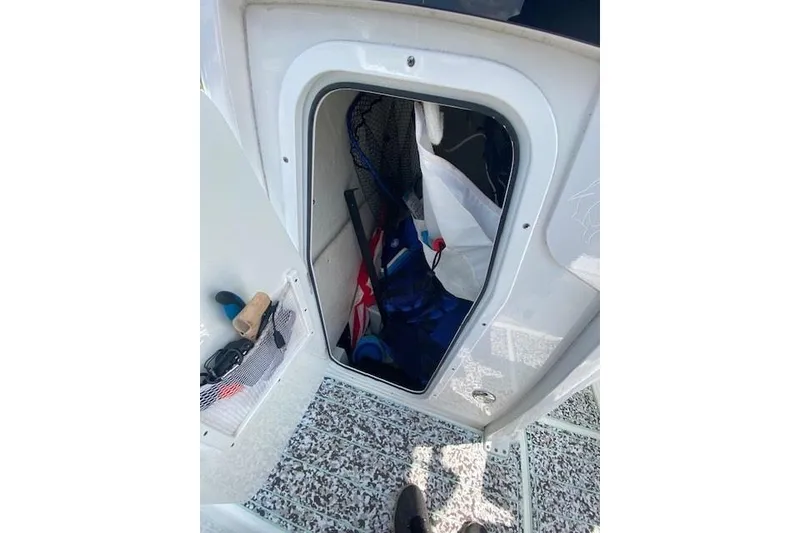 Slide: The Image of 2024 Sea Hunt BX 25 FS boat storage compartment with gear and accessories. - 27