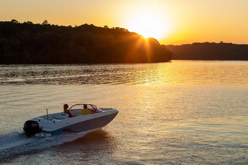 Slide: The Image of 2024 Bayliner Element E21 boat cruising at sunset on a serene lake. - 10