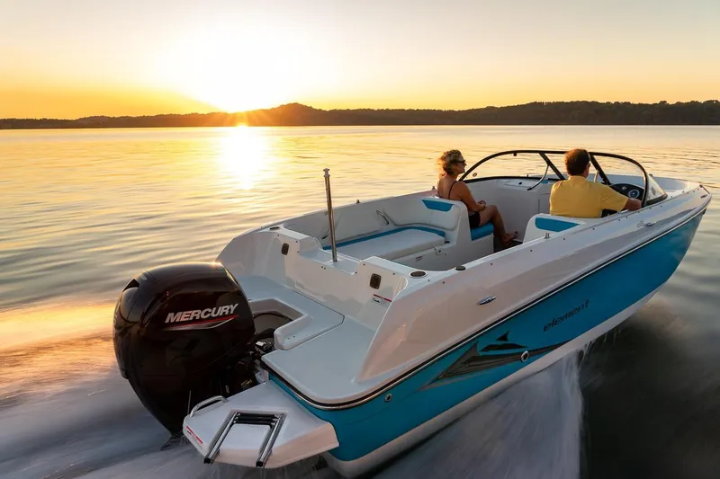 Slide: The Image of 2024 Bayliner Element E21 boat cruising at sunset on a serene lake. - 11