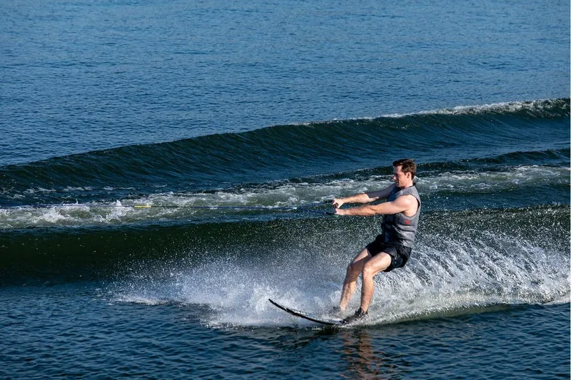 Slide: The Image of Man waterskiing behind 2024 Bayliner Element E21 on a sunny day. - 12