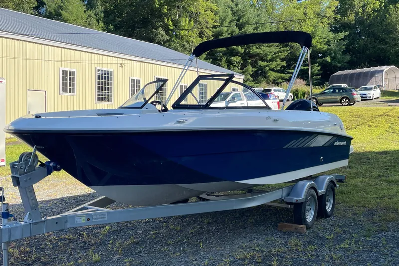 Slide: The Image of 2024 Bayliner Element E21 boat on trailer, parked outdoors near a building. - 3