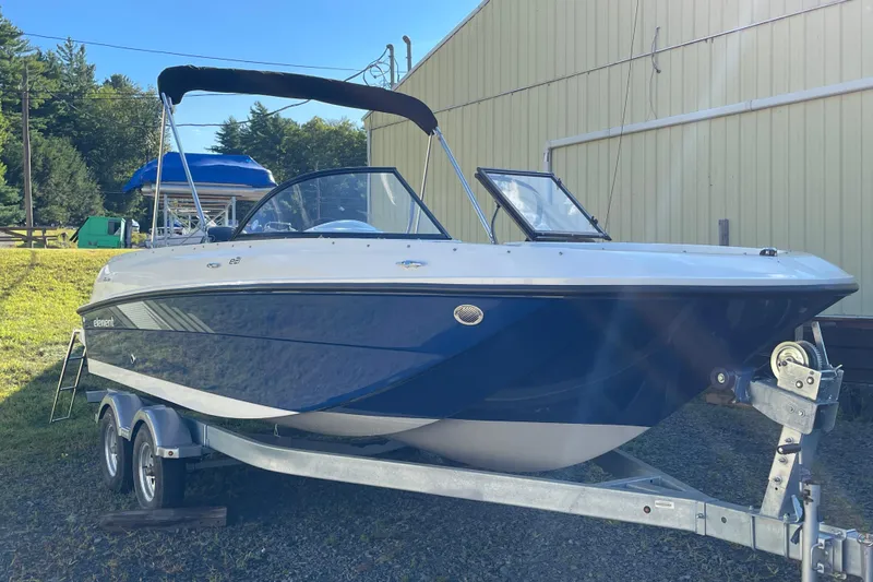 Slide: The Image of 2024 Bayliner Element E21 boat on trailer, parked outdoors near a building. - 6