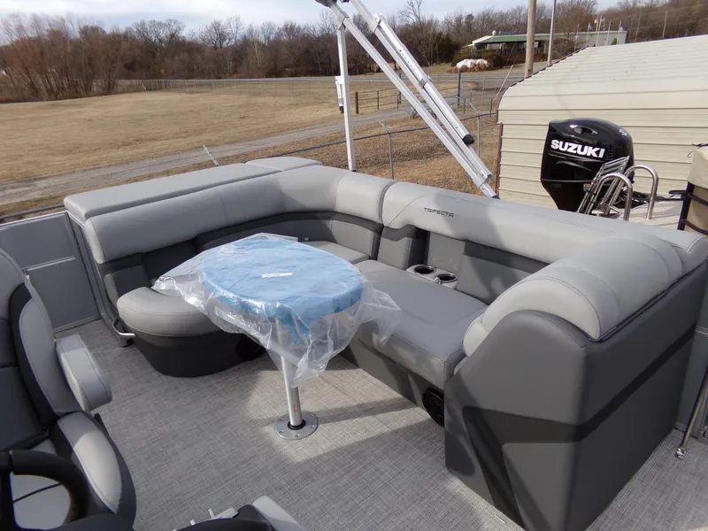 Slide: The Image of 2023 Trifecta 20C CS pontoon boat interior with gray seating and a covered table. - 11