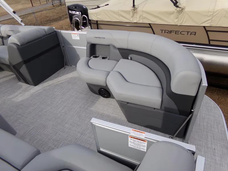 Slide: The Image of 2023 Trifecta 20C CS pontoon boat interior with gray seating and Suzuki engine. - 5