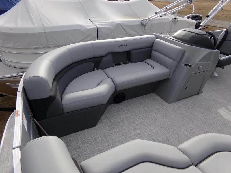 Slide: The Image of 2023 Trifecta 20C CS pontoon boat with gray seating and covered controls. - 6