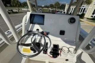 Slide: The Image of 2024 Key West 219 FS boat console with steering wheel and navigation display. - 12