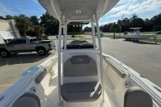 Slide: The Image of 2024 Key West 219 FS boat interior with seating and console, parked outdoors. - 13