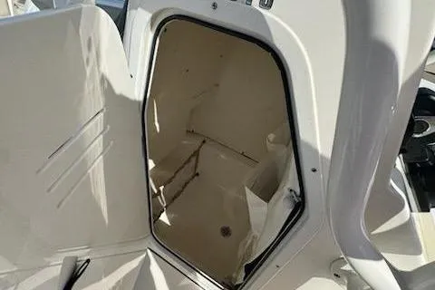 Slide: The Image of 2024 Key West 219 FS boat storage compartment, open and empty, with white interior. - 16