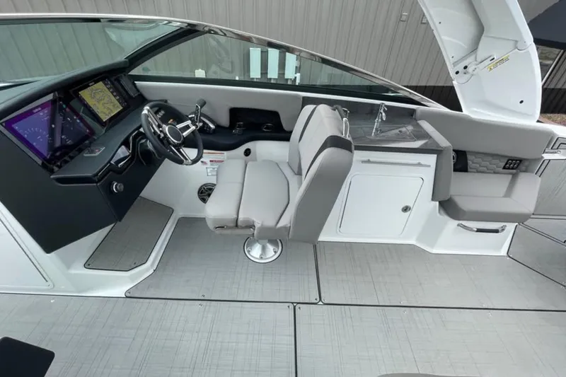 Slide: The Image of 2026 Four Winns H9 boat interior with modern dashboard, steering wheel, and seating. - 11
