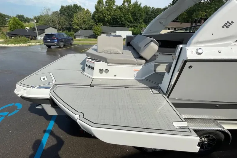 Slide: The Image of 2026 Four Winns H9 boat with spacious deck and seating in a parking lot. - 2