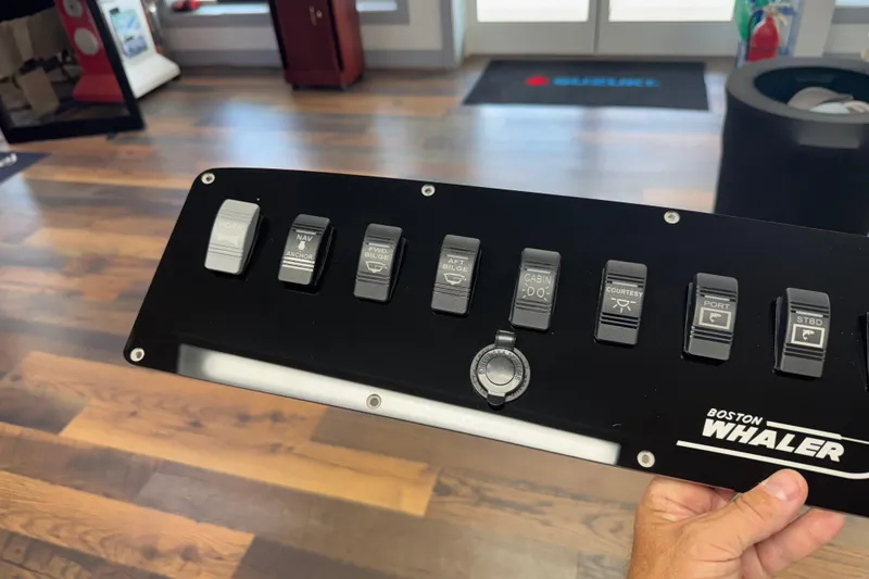 Slide: The Image of Control panel of a 2003 Boston Whaler 240 Outrage boat with various switches. - 6