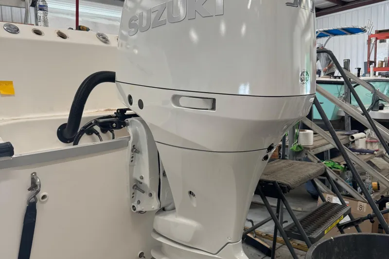 Slide: The Image of 2003 Boston Whaler 240 Outrage with Suzuki outboard motor in a workshop setting. - 7