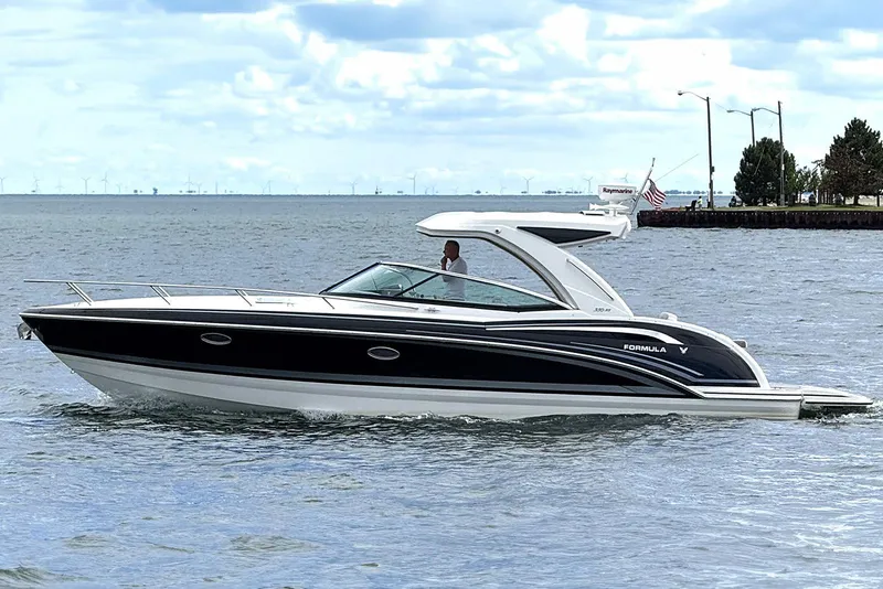 Slide: The Image of 2018 Formula 350 Sun Sport boat cruising on a calm lake under a cloudy sky. - 0
