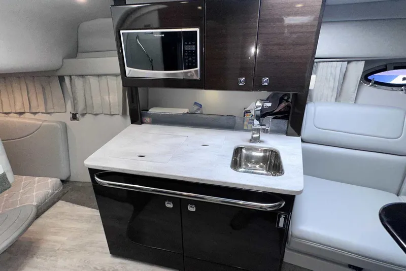 Slide: The Image of Interior of 2018 Formula 350 Sun Sport boat featuring a compact kitchenette with sink and microwave. - 36