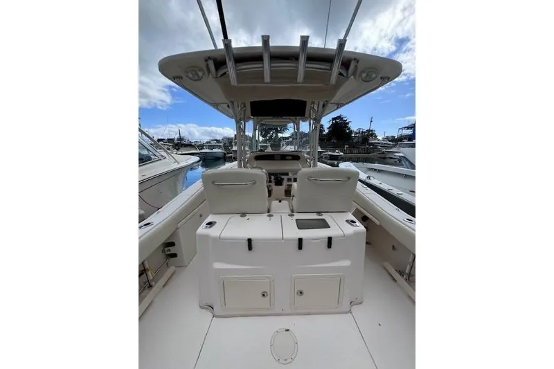 Slide: The Image of 2011 Grady-White Canyon 306 boat interior, featuring helm and seating, docked at marina. - 10