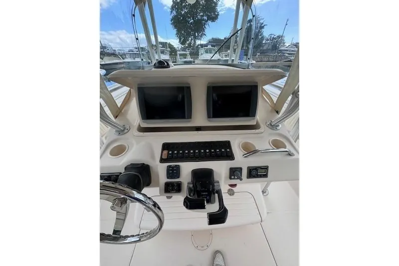 Slide: The Image of 2011 Grady-White Canyon 306 boat dashboard with dual screens and controls. - 11