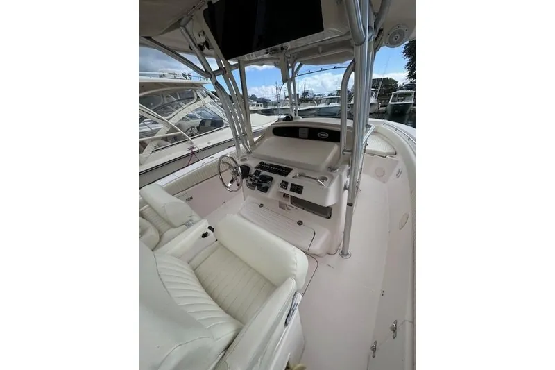 Slide: The Image of 2011 Grady-White Canyon 306 boat interior with helm and seating, docked at marina. - 18