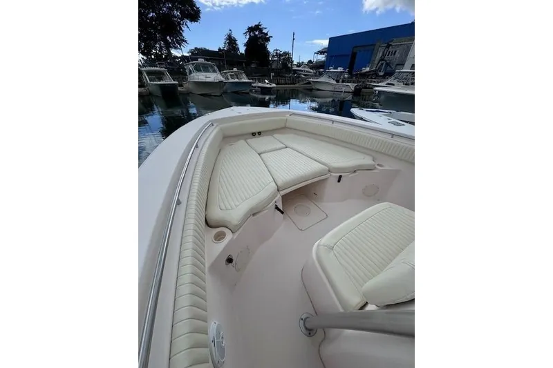 Slide: The Image of 2011 Grady-White Canyon 306 boat interior with cushioned seating in a marina setting. - 8