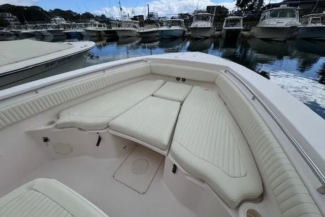 Slide: The Image of 2011 Grady-White Canyon 306 boat interior with cushioned seating in a marina. - 9