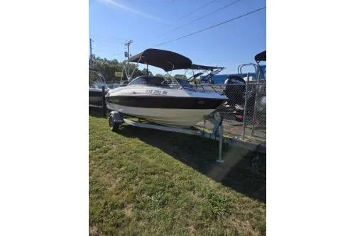 The Image of 2013 Bayliner 185 Bowrider boat on trailer, parked on grass under clear sky. - 1