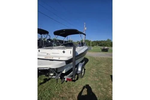 Slide: The Image of 2013 Bayliner 185 Bowrider boat on trailer, parked on grass under clear blue sky. - 3
