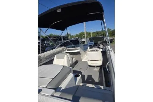 Slide: The Image of 2013 Bayliner 185 Bowrider boat interior with seating and canopy, parked outdoors. - 5