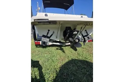 Slide: The Image of 2013 Bayliner 185 Bowrider boat rear view, showcasing propeller and outboard motor on grass. - 9