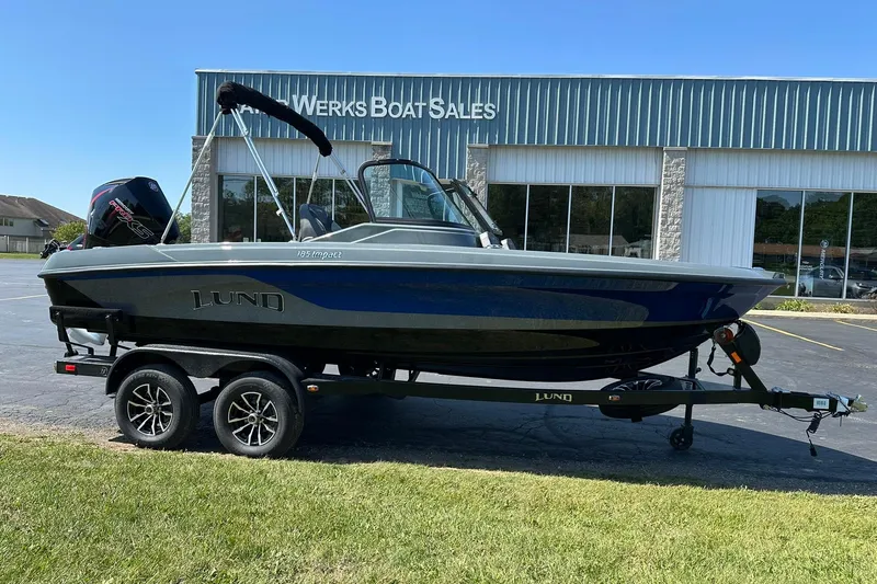 The Image of 2026 Lund 185 Impact GL boat on trailer outside dealership. - 0