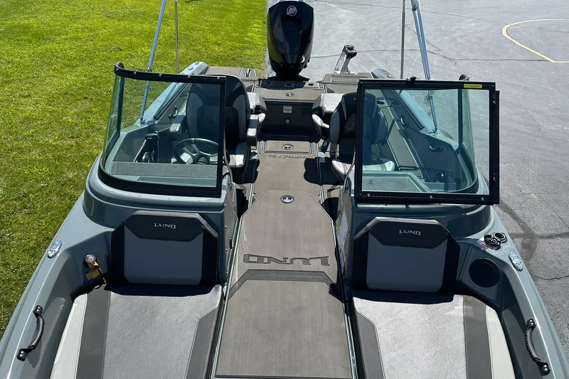 Slide: The Image of 2026 Lund 185 Impact GL boat interior with open windshield, gray seating, and modern design. - 28