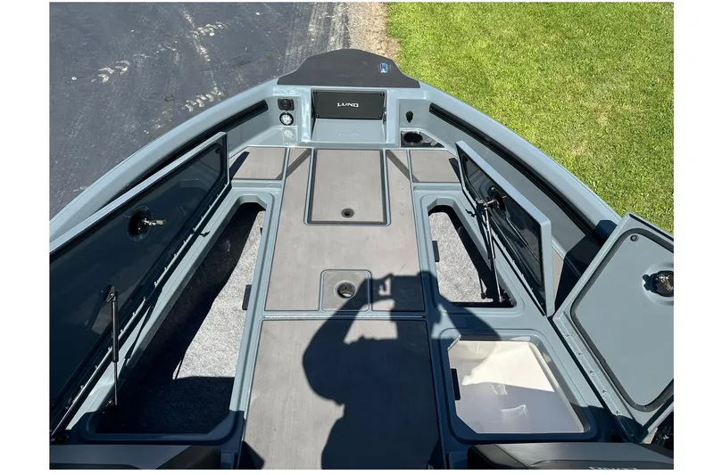 Slide: The Image of 2026 Lund 185 Impact GL boat interior with open storage compartments and shadow on deck. - 32