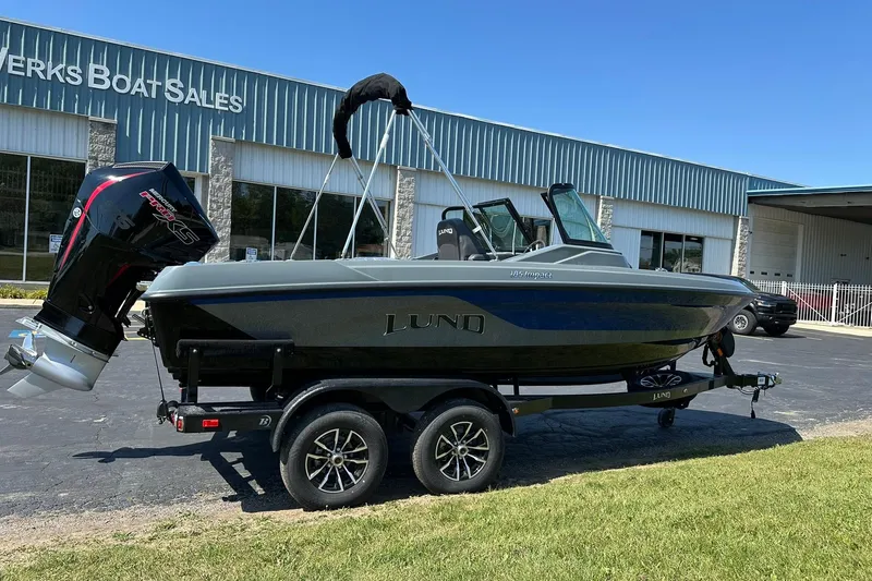 Slide: The Image of 2026 Lund 185 Impact GL boat on trailer outside dealership. - 4