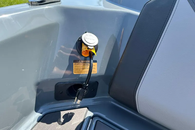 Slide: The Image of 2026 Lund 185 Impact GL boat interior with power outlet and warning label. - 41