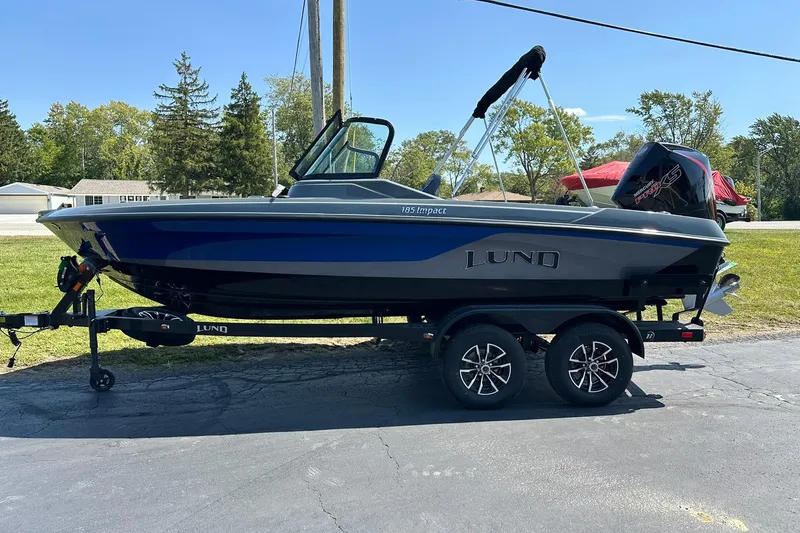 Slide: The Image of 2026 Lund 185 Impact GL boat on trailer, parked outdoors on a sunny day. - 6