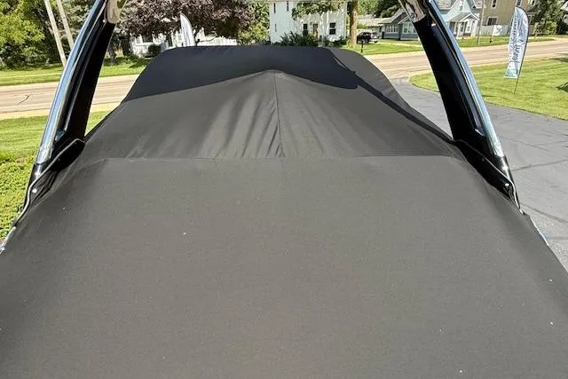 Slide: The Image of 2026 Regal LS4 boat with black cover, parked outdoors on a sunny day. - 35