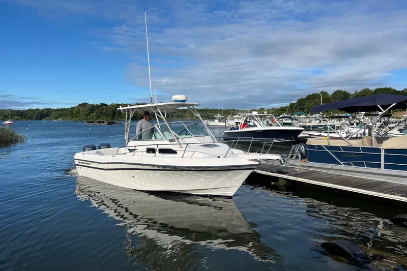 Slide: The Image of 1999 Grady-White Gulfstream 232 boat docked in a scenic marina setting. - 1