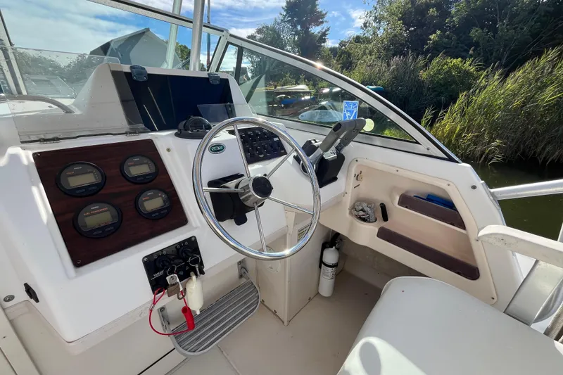 Slide: The Image of 1999 Grady-White Gulfstream 232 boat cockpit with steering wheel and instrument panel. - 14