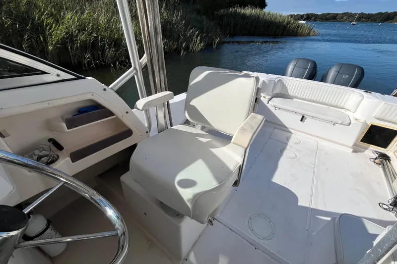 Slide: The Image of 1999 Grady-White Gulfstream 232 boat interior with seating and steering wheel, near water. - 15