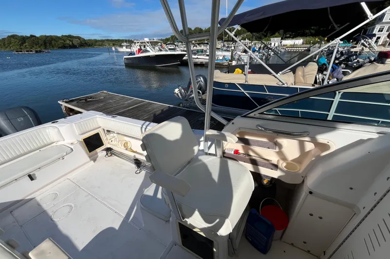 Slide: The Image of 1999 Grady-White Gulfstream 232 boat interior at a marina, featuring seating and storage. - 16