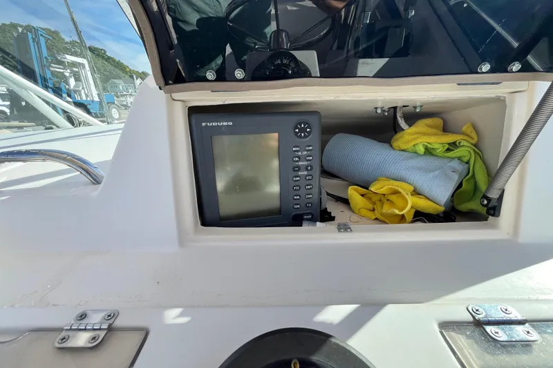 Slide: The Image of 1999 Grady-White Gulfstream 232 boat dashboard with Furuno navigation system and cleaning supplies. - 17