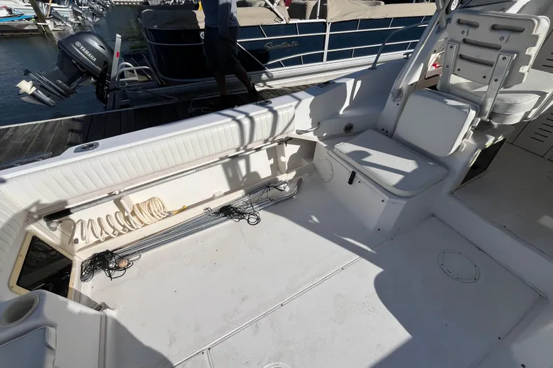 Slide: The Image of 1999 Grady-White Gulfstream 232 boat interior with seating and storage at a marina. - 18