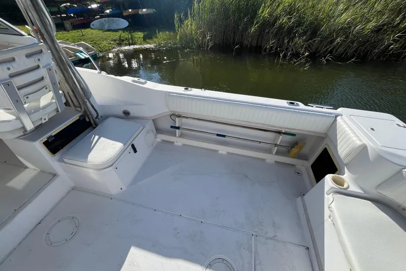 Slide: The Image of 1999 Grady-White Gulfstream 232 boat interior with seating and storage, near water and reeds. - 19