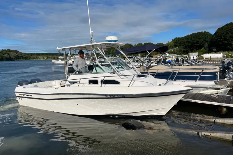 Slide: The Image of 1999 Grady-White Gulfstream 232 boat docked at marina under clear sky. - 2