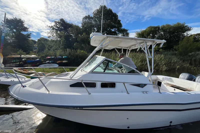 Slide: The Image of 1999 Grady-White Gulfstream 232 boat docked by lush greenery under a blue sky. - 3
