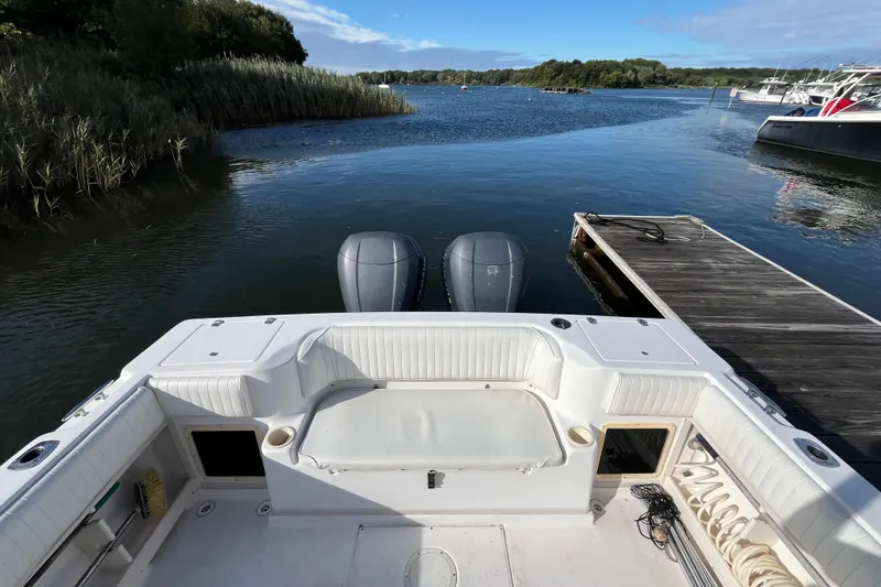 Slide: The Image of 1999 Grady-White Gulfstream 232 boat docked on a serene lake with lush greenery. - 8
