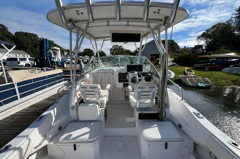 Slide: The Image of 1999 Grady-White Gulfstream 232 boat interior with helm and seating, docked by the water. - 9