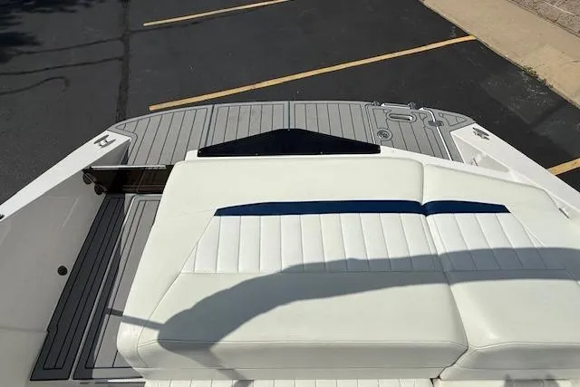 Slide: The Image of 2012 Regal 2000 Bowrider boat with white seating and gray deck in a parking lot. - 21
